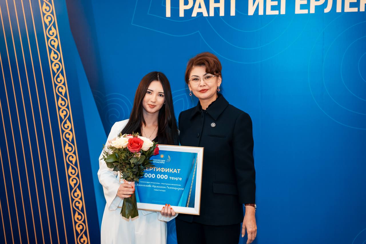 Narmina receiving the government grant certificate with flowers